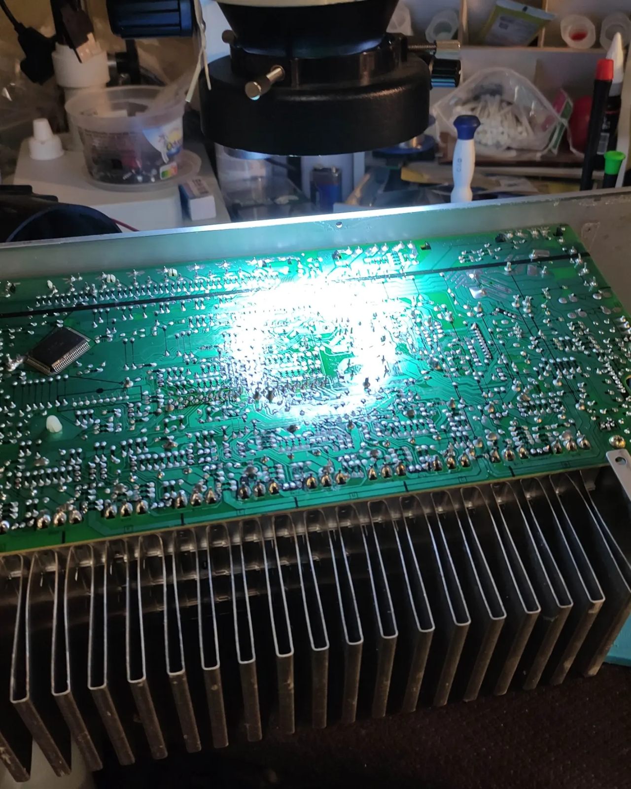 Carte de l'ampli Sony retournée sous le microscope, côté soudures