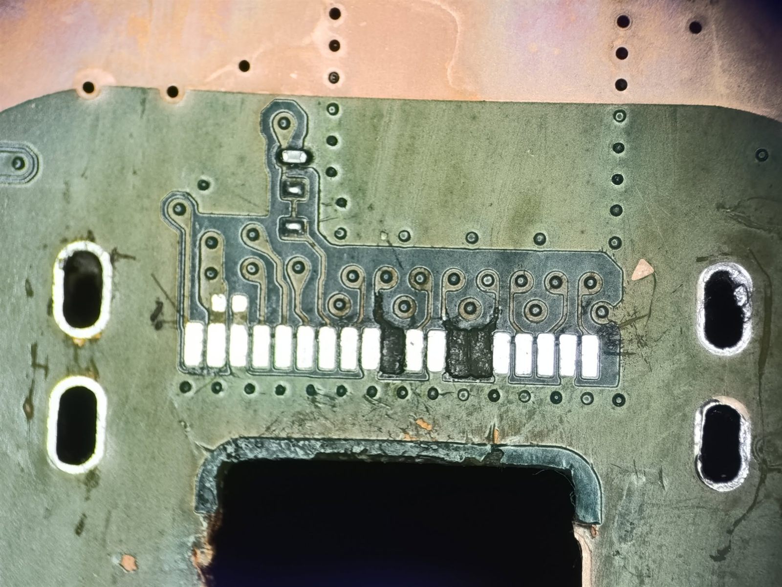 Emplacement de la prise HDMI nettoyé au microscope, pistes arrachées visibles