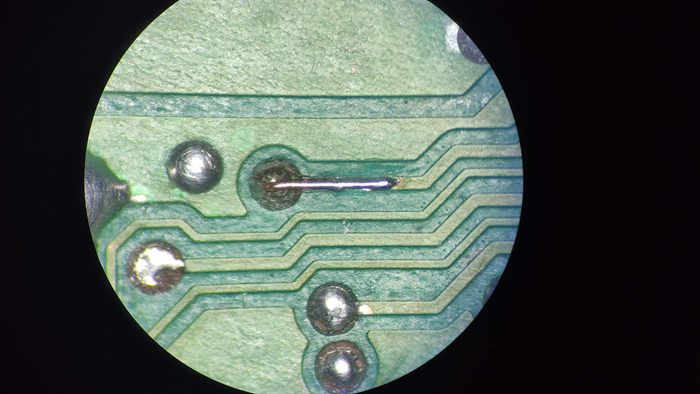 Piste de carte électronique réparée, vue au microscope