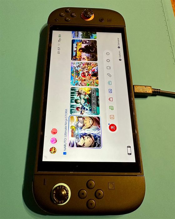 Nintendo Switch 2 réparée, allumée sur l'écran d'accueil et branchée en charge